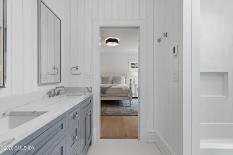 a en suite bathroom with a granite countertop sink and a mirror