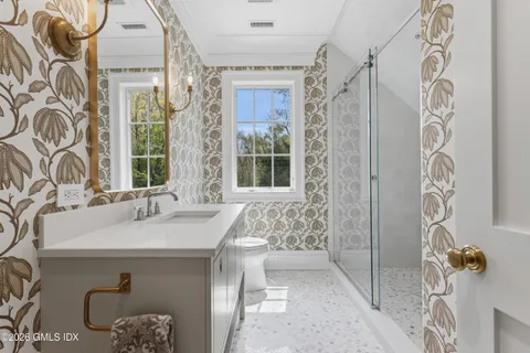 a bathroom with a sink and mirror with bathtub