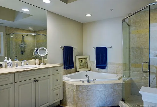 a bathroom with a tub sink and mirror