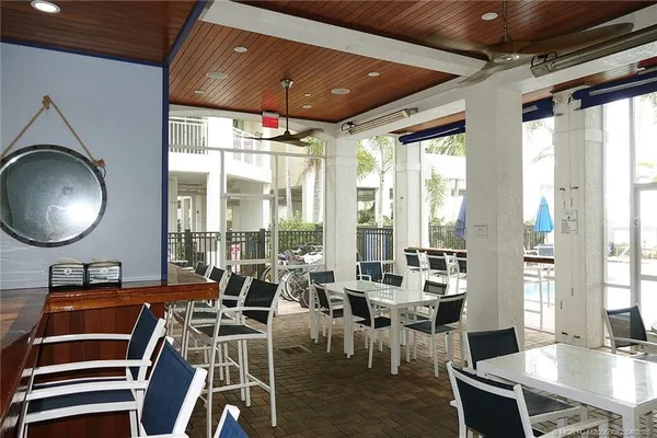 a room with lots of tables a large window and chairs