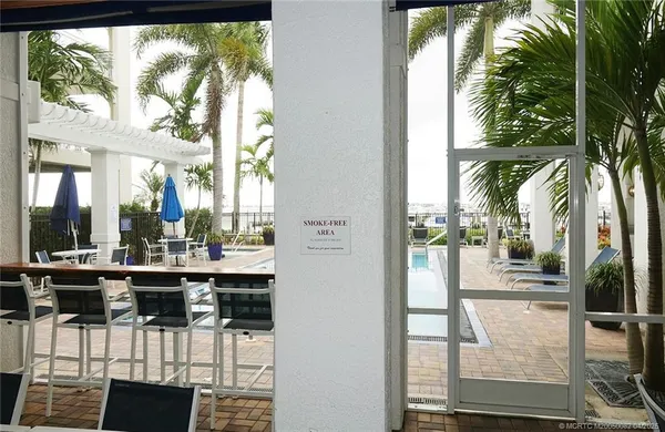 a view of a dining room with a floor to ceiling window and kitchen