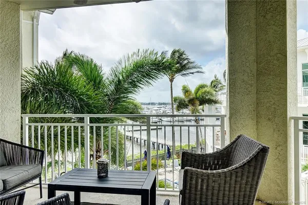 a balcony with wooden floor table and chairs