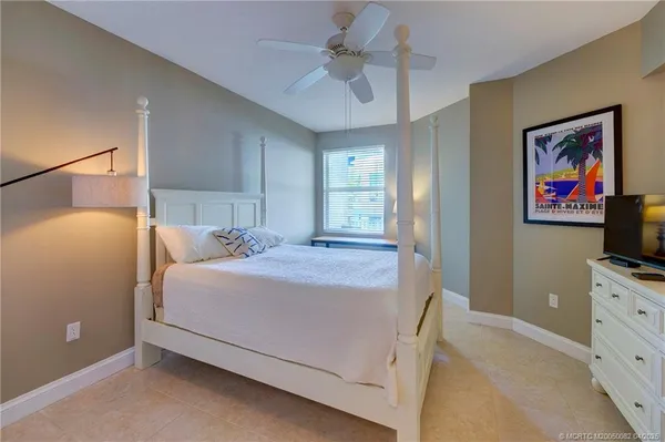 a bedroom with a bed and a flat tv screen on dresser