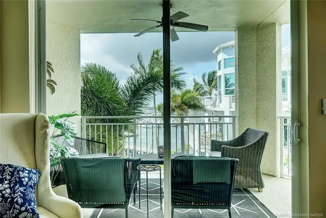 a balcony with table and chairs and potted plants