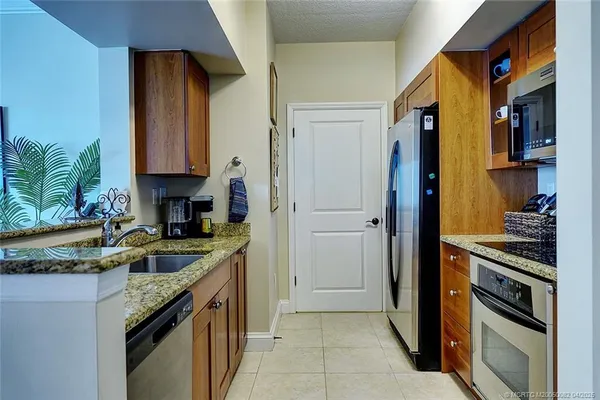 a kitchen with granite countertop a sink stove and cabinets