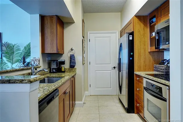 a kitchen with granite countertop a sink stove and cabinets
