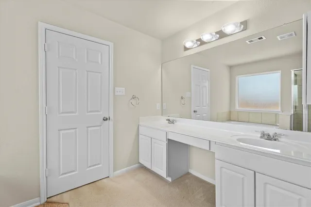 a spacious bathroom with a double vanity sink a mirror and a bathtub
