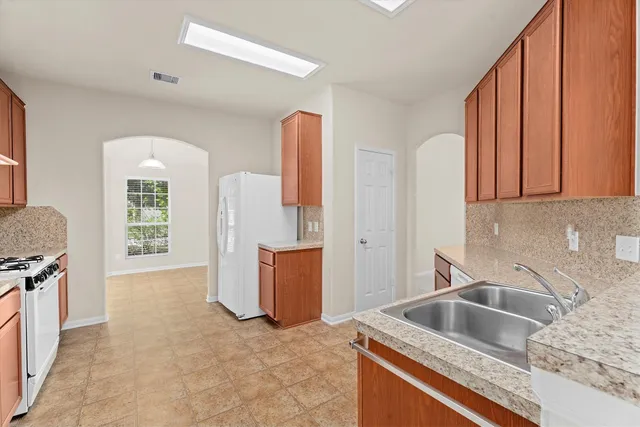 a kitchen that has a sink cabinets and a stove