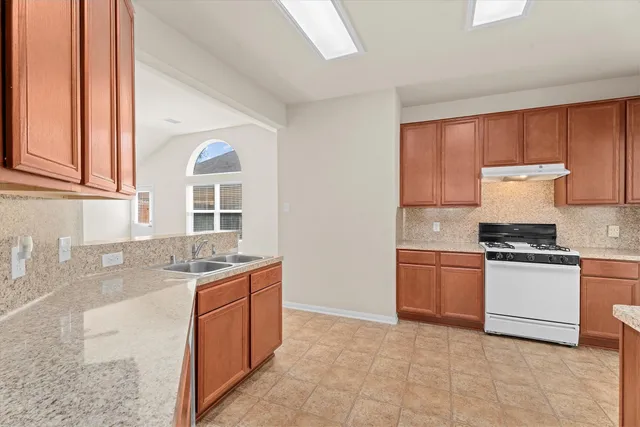 a kitchen with stainless steel appliances granite countertop a sink stove and cabinets