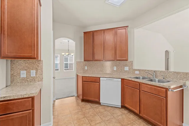 a kitchen with stainless steel appliances granite countertop a sink and cabinets with wooden floor