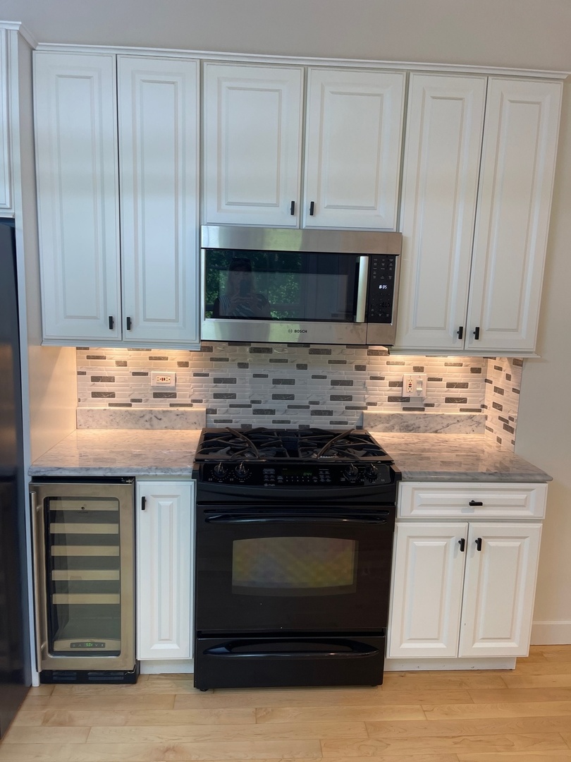 1338 Trinity Place Libertyville, IL 60048 - Photo 6 of 24 a kitchen with granite countertop white cabinets and stainless steel appliances