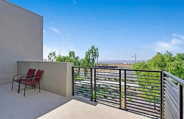 a view of a balcony with chairs and a potted plant