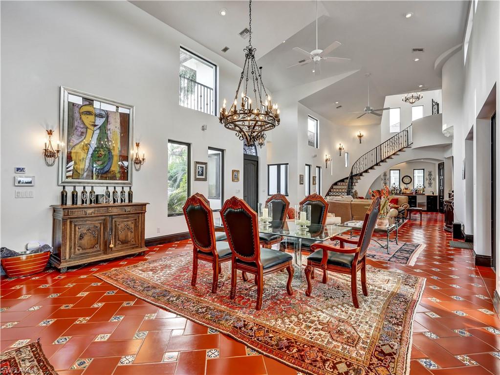 2535 Tarpon Road Naples, FL 34102 - Photo 12 of 50 High ceilings featuring an ornate chandelier, dark wood cabinetry, a built-in bar, and high transom windows