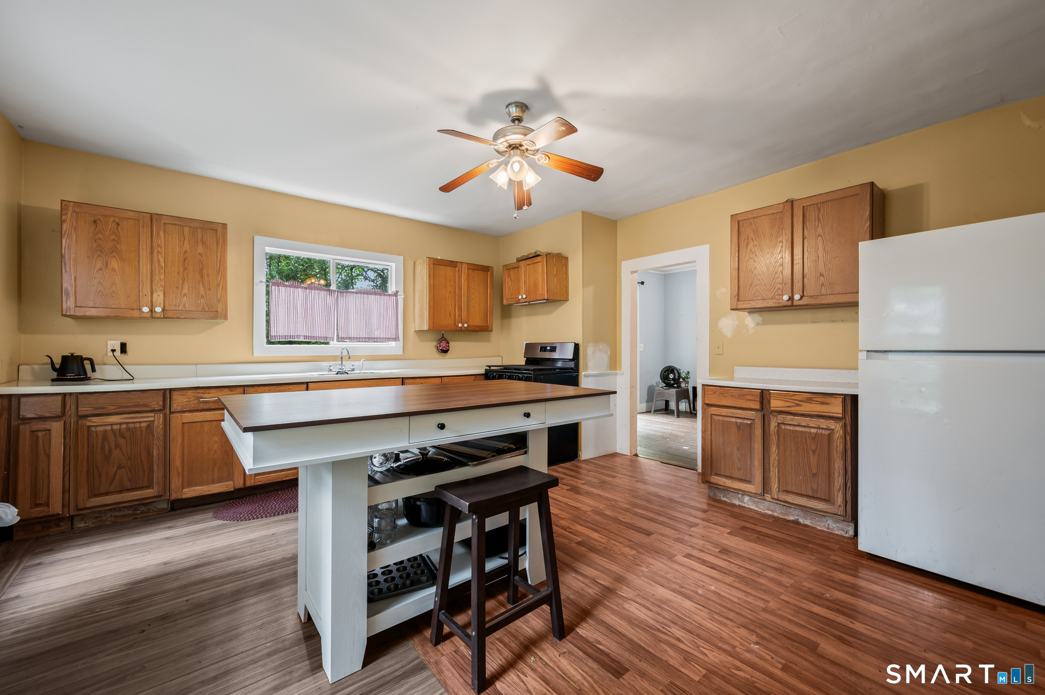 220 Murray Street Meriden, CT 06450 - Photo 3 of 28 a kitchen with a refrigerator a sink dishwasher a stove and white cabinets with wooden floor