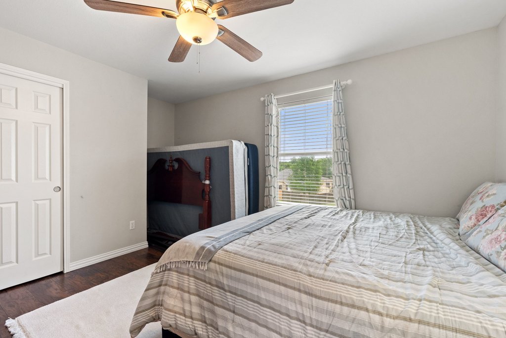 140 Wolfberry Path Buda, TX 78610 - Photo 28 of 35 a bedroom with a bed and wooden floor