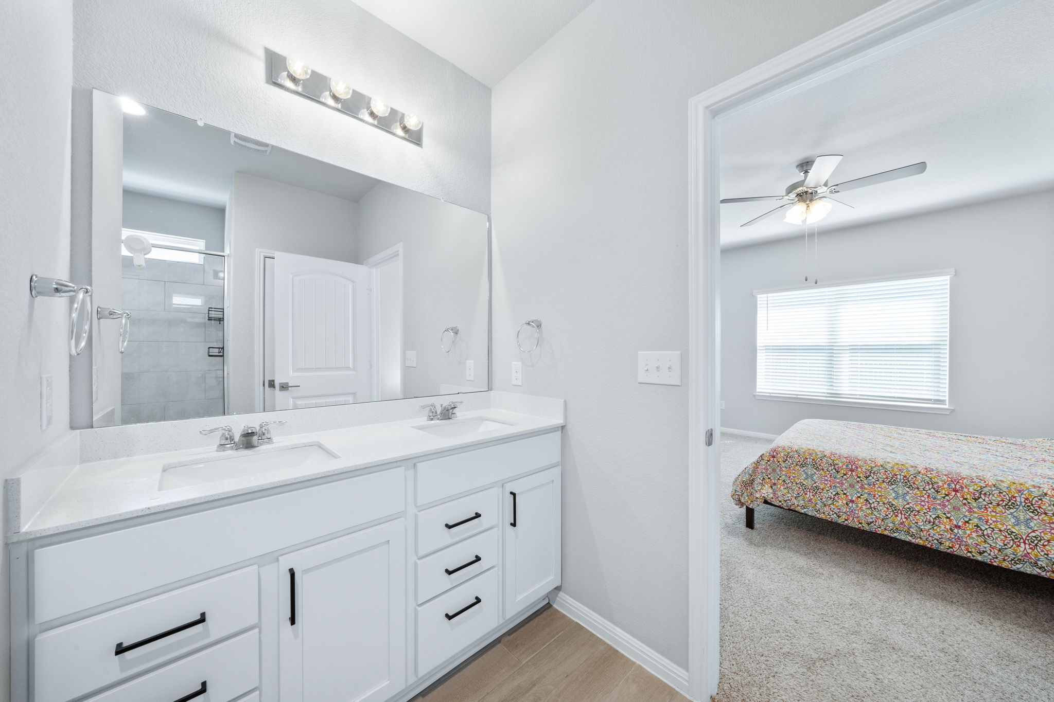 2412 Starhill Ranch Street Georgetown, TX 78628 - Photo 27 of 40 Double vanity with sleek white cabinetry and modern fixtures offers abundant counter space in this bright bathroom.