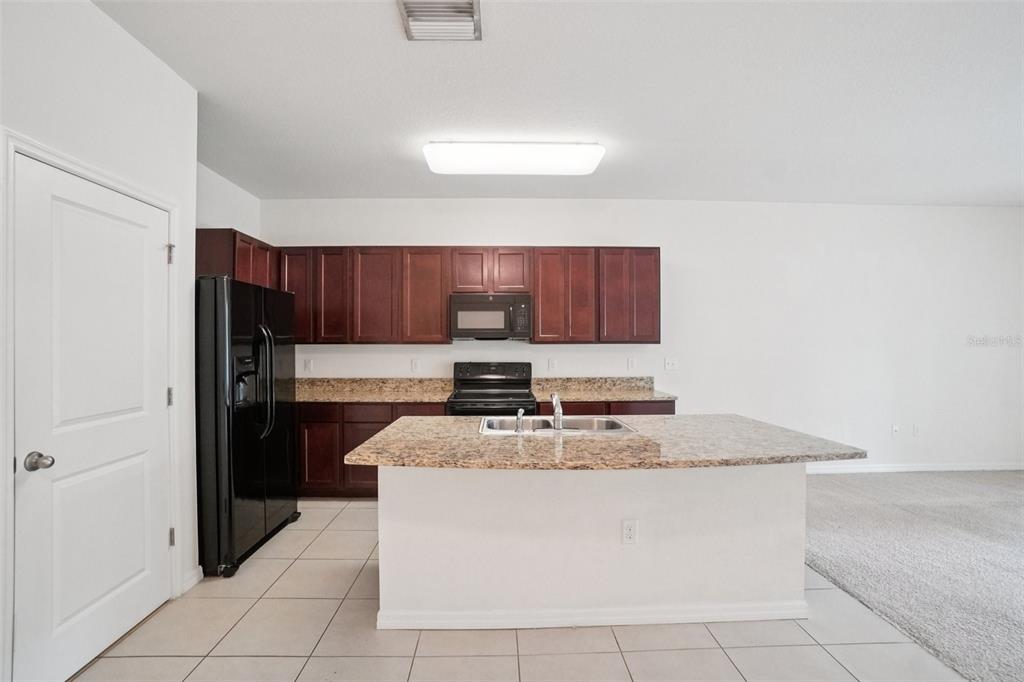 8986 Indigo Trail Loop Riverview, FL 33578 - Photo 19 of 48 a kitchen with stainless steel appliances granite countertop a stove a sink and a refrigerator
