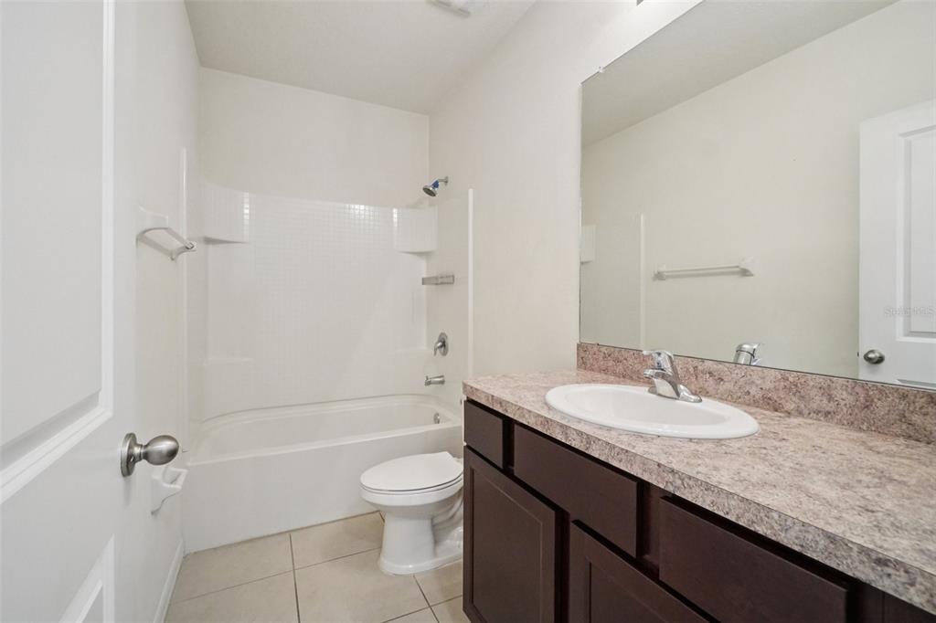 8986 Indigo Trail Loop Riverview, FL 33578 - Photo 25 of 48 a bathroom with a granite countertop sink toilet and shower