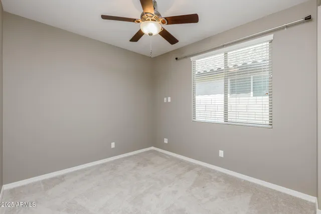 an empty room with a window and a fan
