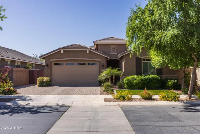 a front view of a house with a yard and potted plants