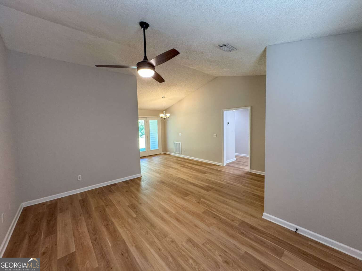 110 Talbot Court St. Marys, GA 31558 - Photo 2 of 16 a view of an empty room with wooden floor and a ceiling fan