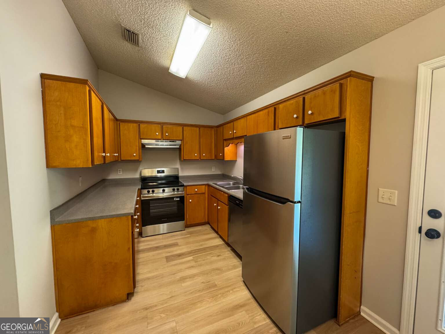 110 Talbot Court St. Marys, GA 31558 - Photo 4 of 16 a kitchen with stainless steel appliances granite countertop a refrigerator a stove and a sink
