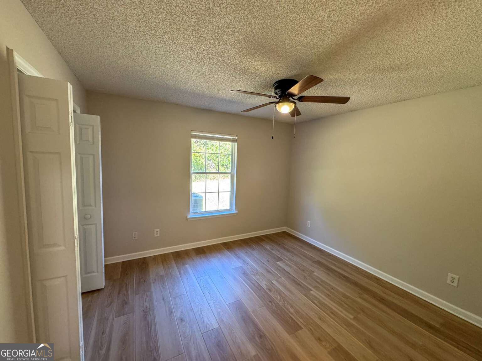 110 Talbot Court St. Marys, GA 31558 - Photo 5 of 16 an empty room with wooden floor fan and windows