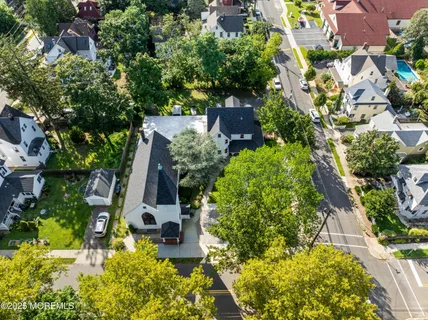 an aerial view of a house with swimming pool garden and lake view