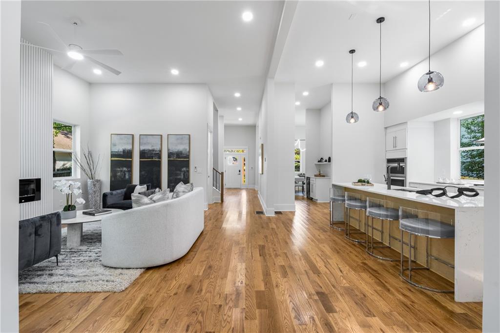271 Haas Avenue Southeast Atlanta, GA 30316 - Photo 17 of 56 a living room with stainless steel appliances kitchen island granite countertop a couch a stove a dining table and chairs with wooden floor