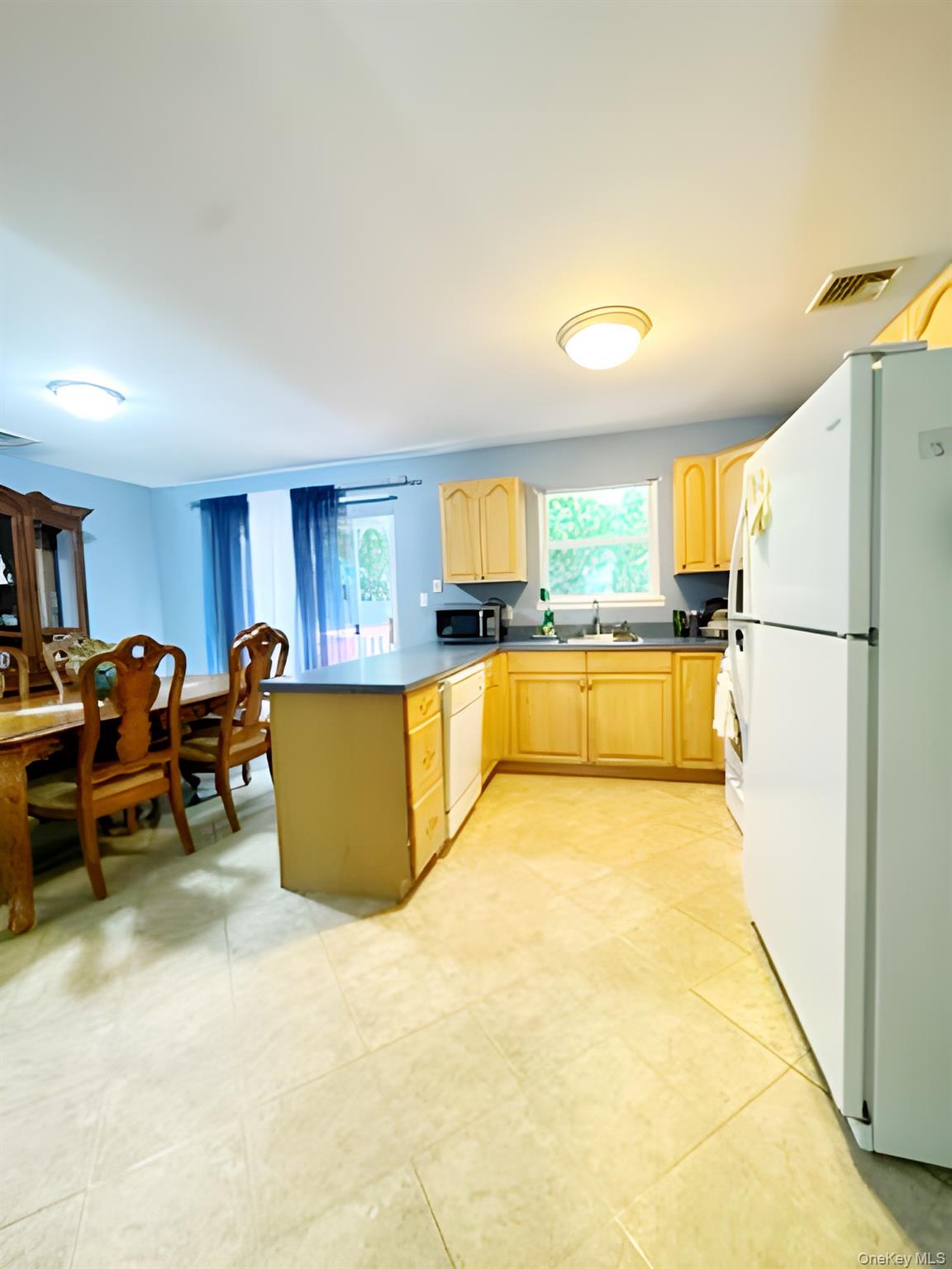 60 Aloma Road Rocky Point, NY 11778 - Photo 12 of 34 Kitchen with white appliances, light brown cabinetry, a peninsula, and healthy amount of natural light