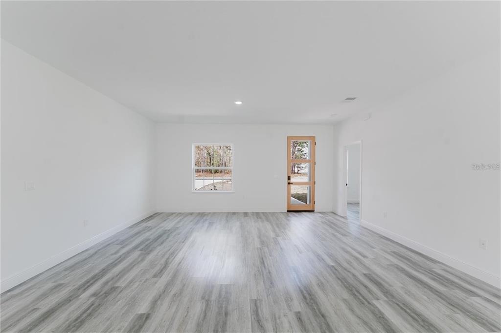 6732 Southwest 132nd Street Ocala, FL 34473 - Photo 14 of 36 an empty room with wooden floor and windows