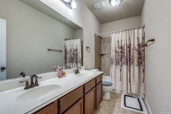 a bathroom with a sink a toilet and shower curtain