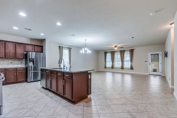 a large kitchen with stainless steel appliances granite countertop a large counter top and a stove top oven