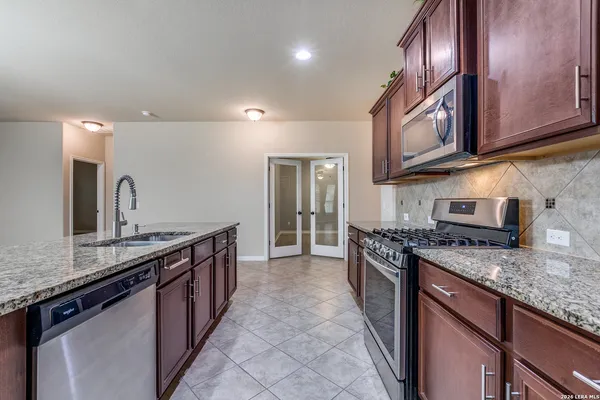 a kitchen with stainless steel appliances granite countertop a sink stove and cabinets