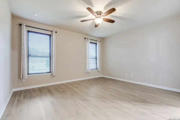 a view of an empty room with a window and a ceiling fan