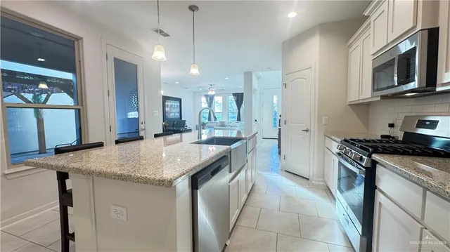 a kitchen with stainless steel appliances granite countertop a sink and a stove