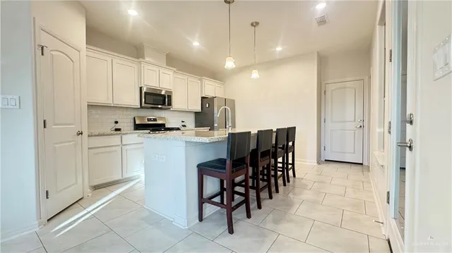 a kitchen with a sink a counter top space appliances and cabinets