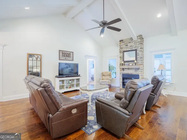 a dining room with wooden floor a chandelier a wooden table and chairs