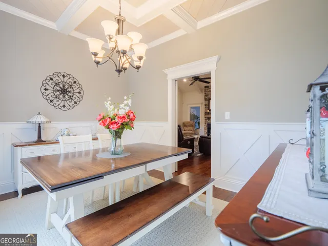 a large kitchen with stainless steel appliances kitchen island granite countertop a large stove a sink dishwasher and white cabinets with wooden floor