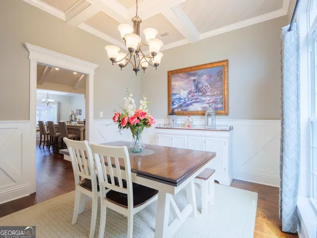 a kitchen with a table chairs and a stove top oven with wooden floor