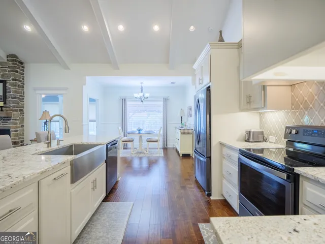 a kitchen with a refrigerator sink and cabinets