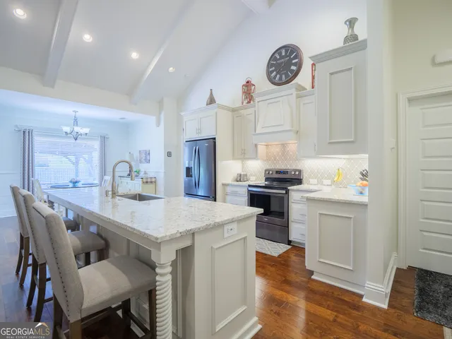 a kitchen with stainless steel appliances granite countertop a refrigerator and a stove top oven