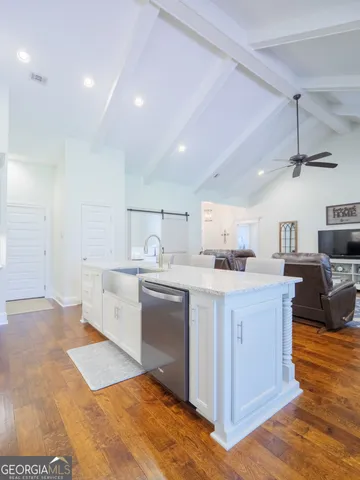 a dining room with wooden floor a chandelier a wooden table and chairs