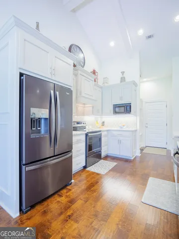 a large kitchen with cabinets wooden floor and stainless steel appliances