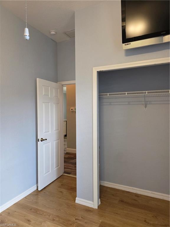 857 Summerfield Drive Naples, FL 34120 - Photo 36 of 50 an empty room with wooden floor and closet