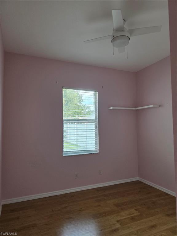 857 Summerfield Drive Naples, FL 34120 - Photo 37 of 50 an empty room with wooden floor and windows