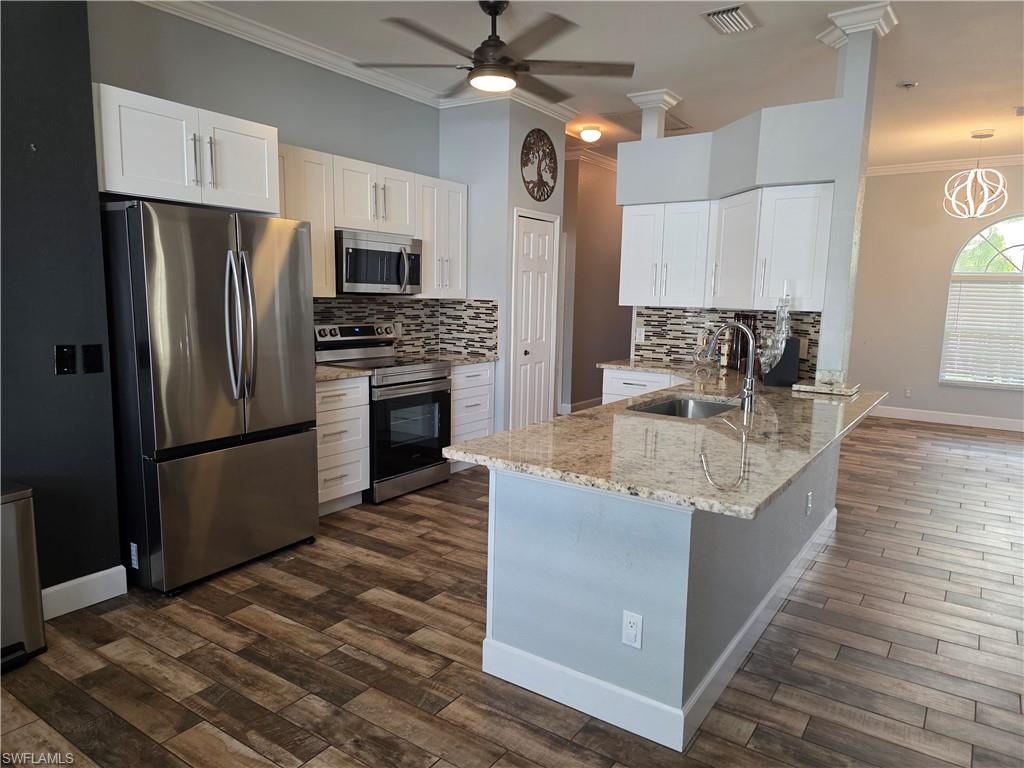 857 Summerfield Drive Naples, FL 34120 - Photo 44 of 50 a kitchen with stainless steel appliances granite countertop a refrigerator a stove a sink and a microwave