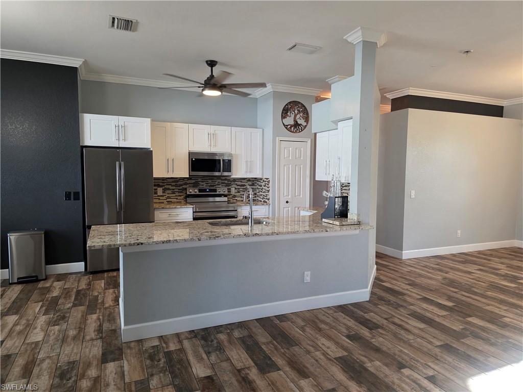 857 Summerfield Drive Naples, FL 34120 - Photo 46 of 50 a living room with stainless steel appliances kitchen island granite countertop a refrigerator a stove top oven a sink and dishwasher