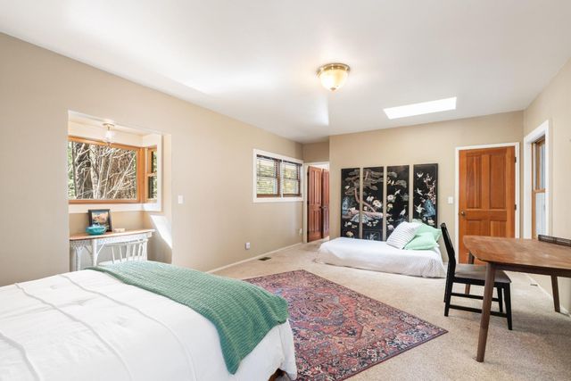 a living room with furniture a large window and stainless steel appliances