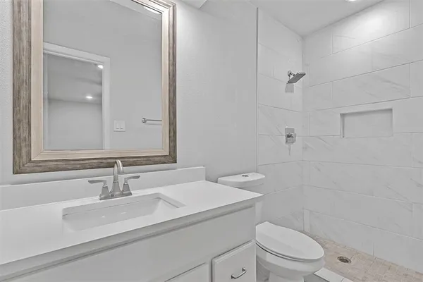 a bathroom with a sink toilet vanity and shower